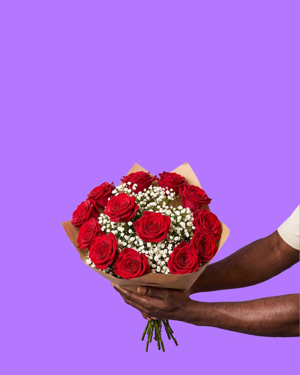 A man's hands holding out a single fresh deep red rose on its stem