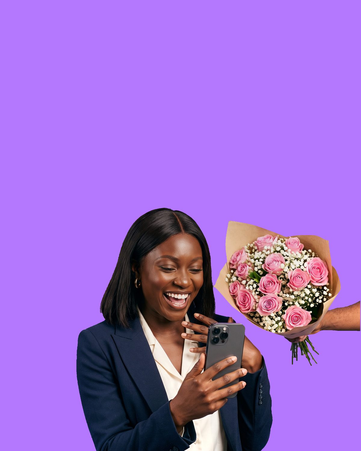 A woman laughing in disbelief at the phone in her hand as a bouquet of pink roses is pushed in from the edge of the frame