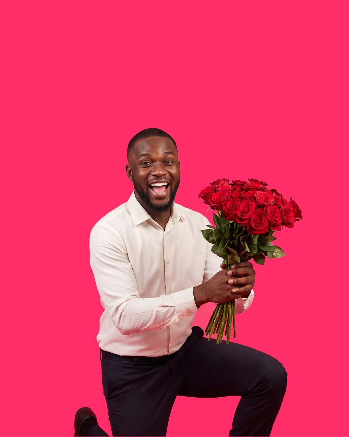 A man down on one knee, holding up a large bouquet of deep red roses with both hands